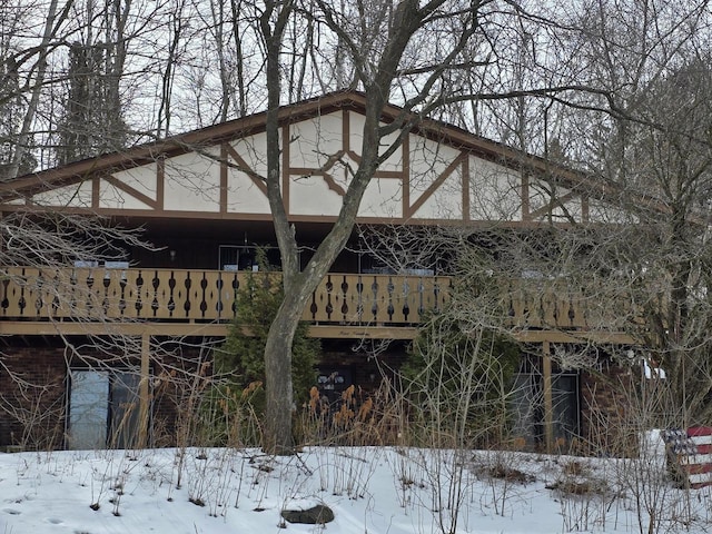 snow covered property with brick siding