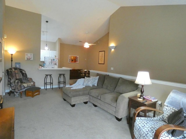 living area with carpet floors, high vaulted ceiling, and baseboards