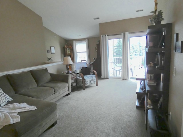 living area with carpet flooring, vaulted ceiling, and visible vents