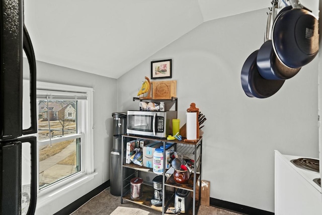 interior space with vaulted ceiling and baseboards