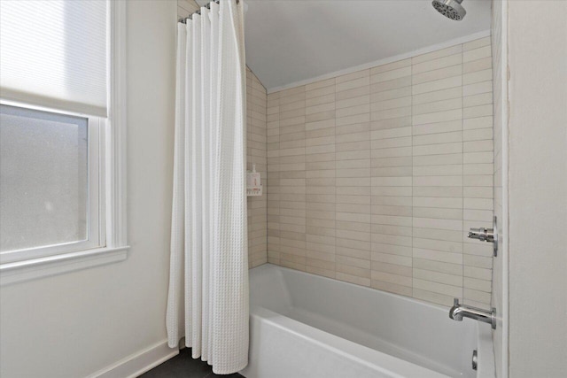 full bathroom with shower / tub combo and baseboards