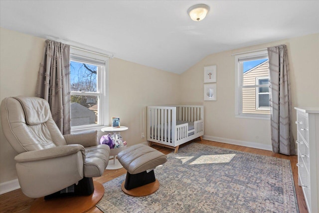 bedroom featuring vaulted ceiling, multiple windows, and wood finished floors