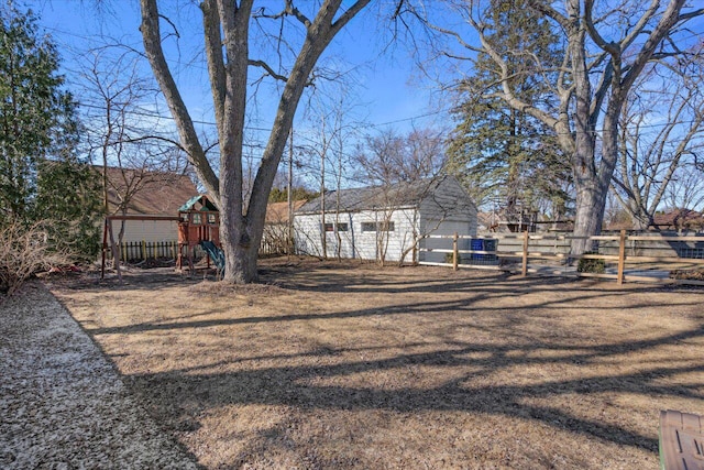 view of yard with a playground, an outbuilding, and fence