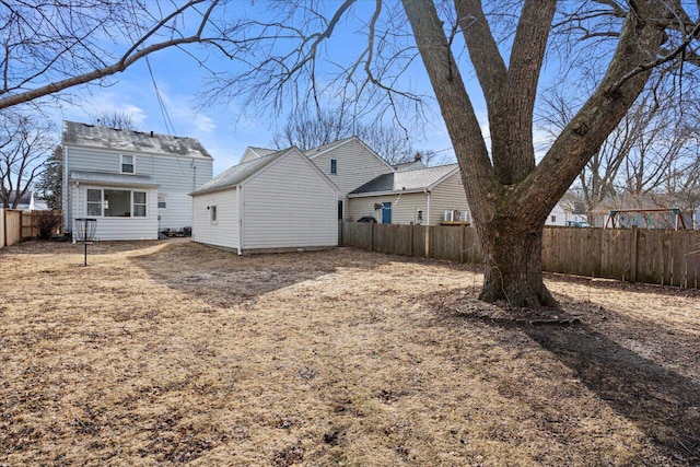 rear view of house with a fenced backyard