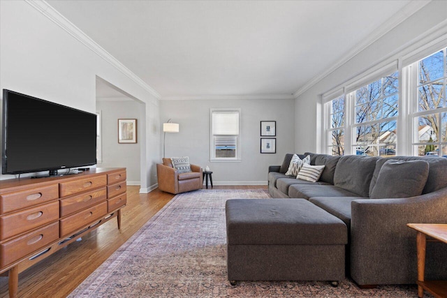 living area with baseboards, wood finished floors, and ornamental molding