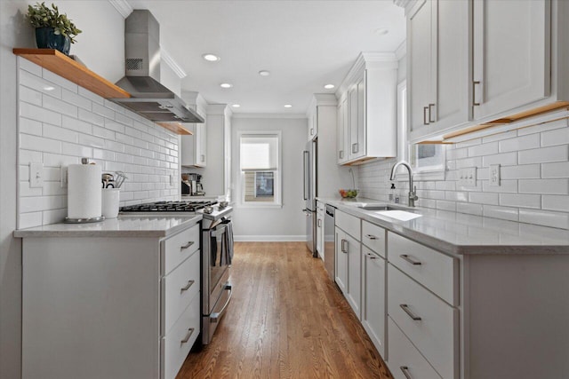 kitchen with open shelves, a sink, ornamental molding, stainless steel appliances, and wall chimney exhaust hood