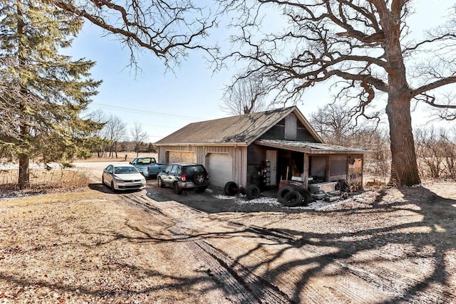 view of home's exterior featuring dirt driveway and an outdoor structure