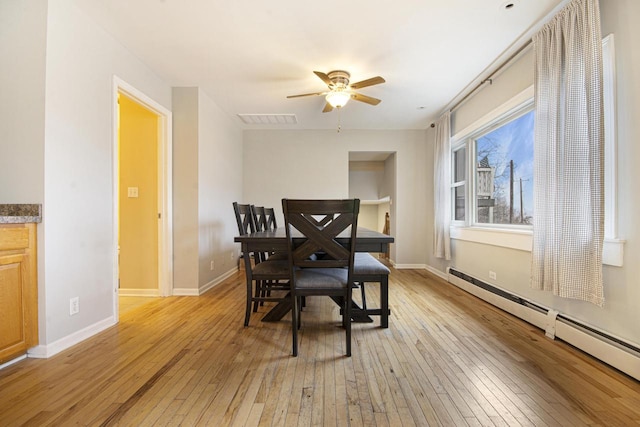 dining area featuring ceiling fan, a baseboard radiator, visible vents, baseboards, and light wood-type flooring