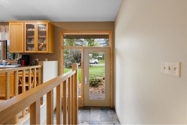 doorway to outside with stone finish flooring