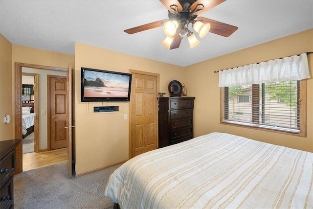 bedroom with light carpet and a ceiling fan