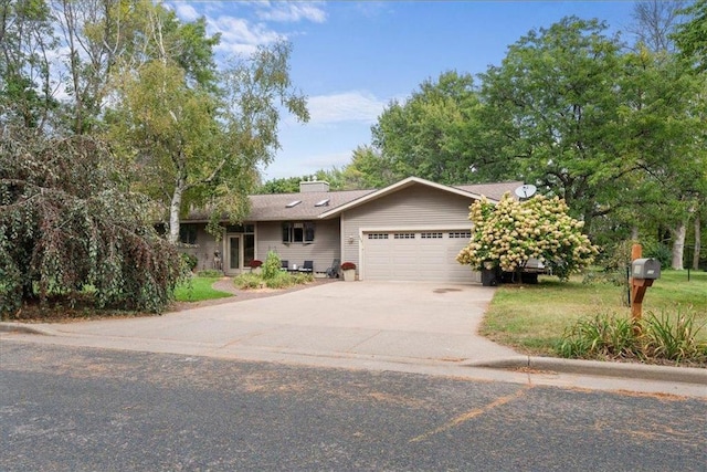 single story home with an attached garage, driveway, and a chimney