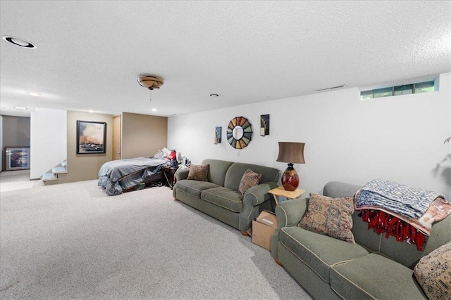 carpeted living area featuring stairs, visible vents, and a textured ceiling