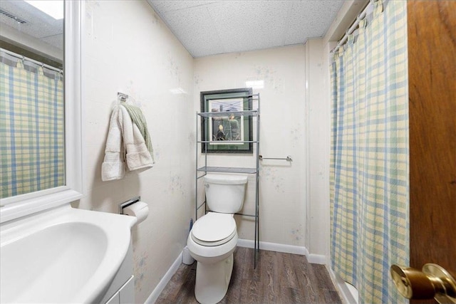 bathroom with toilet, a shower with curtain, baseboards, and wood finished floors