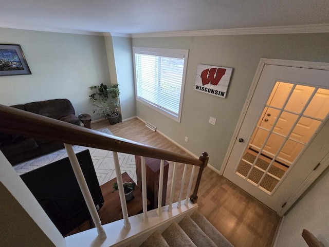 stairway featuring visible vents, crown molding, baseboards, and wood finished floors