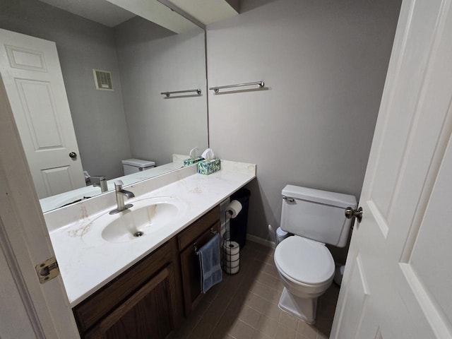 bathroom featuring visible vents, toilet, vanity, tile patterned flooring, and baseboards