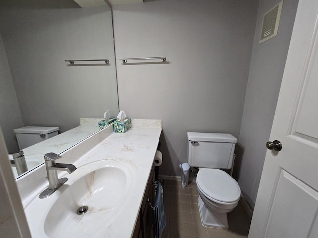 half bathroom featuring tile patterned flooring, baseboards, vanity, and toilet