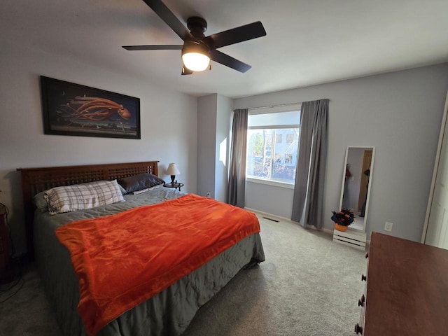 bedroom with visible vents, a ceiling fan, and carpet flooring