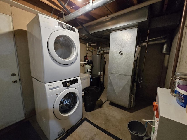 laundry room with stacked washer / drying machine, laundry area, and water heater