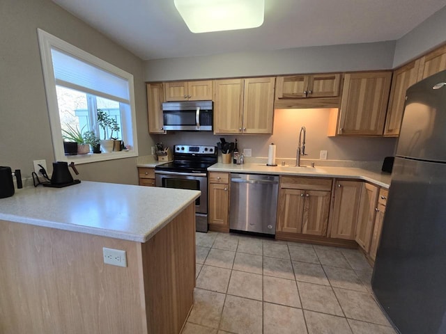 kitchen with light tile patterned flooring, stainless steel appliances, a sink, and light countertops