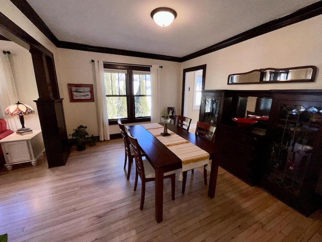 dining area with ornamental molding and wood finished floors