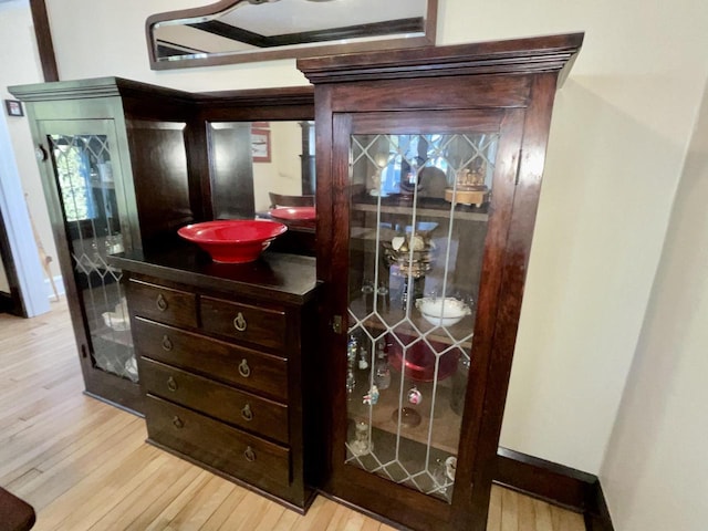 details featuring vanity, baseboards, and wood finished floors