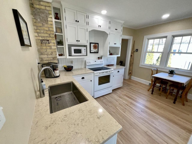 kitchen featuring white appliances, a sink, white cabinets, open shelves, and light wood finished floors