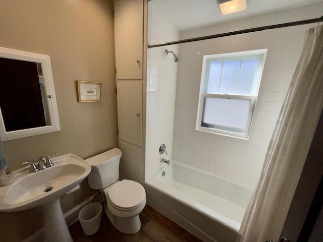 bathroom featuring wood finished floors, shower / bath combo with shower curtain, and toilet