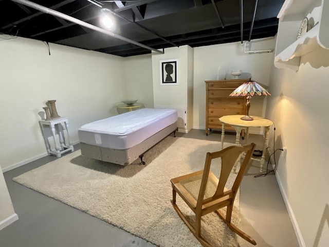 bedroom featuring finished concrete floors and baseboards