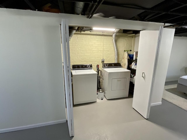 clothes washing area with laundry area, baseboards, and washing machine and clothes dryer