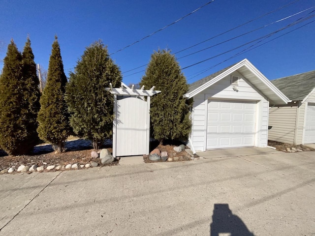 garage featuring concrete driveway