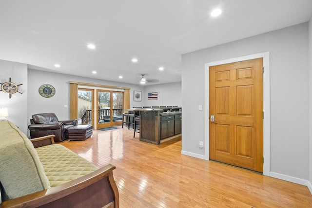 living area featuring light wood-type flooring, baseboards, and recessed lighting