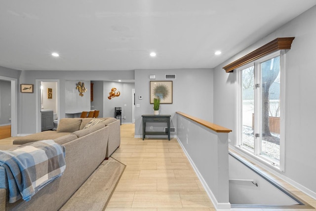 living area featuring light wood-style floors, recessed lighting, visible vents, and baseboards