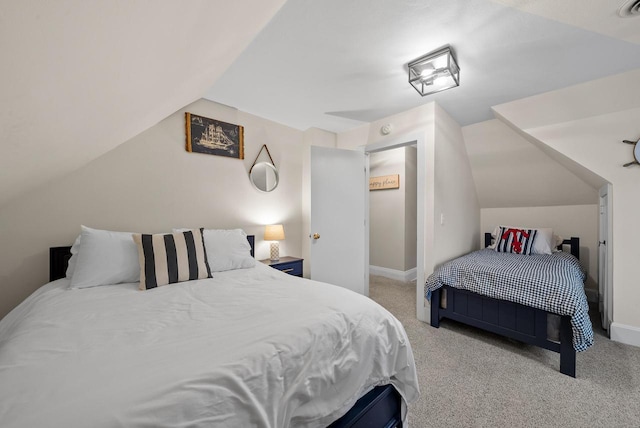 carpeted bedroom with vaulted ceiling and baseboards