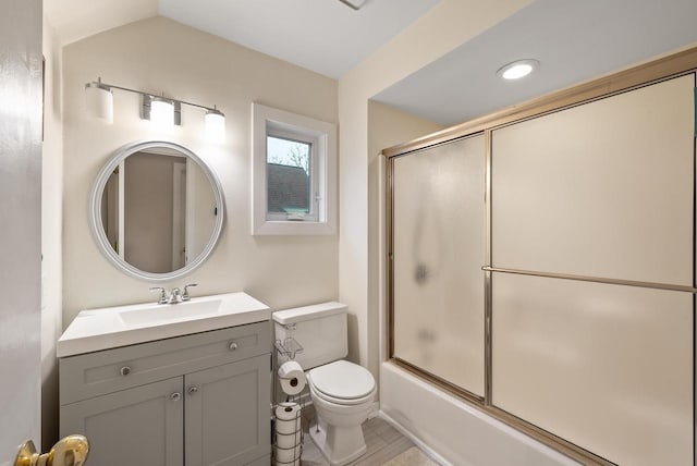 full bath with vaulted ceiling, bath / shower combo with glass door, vanity, and toilet