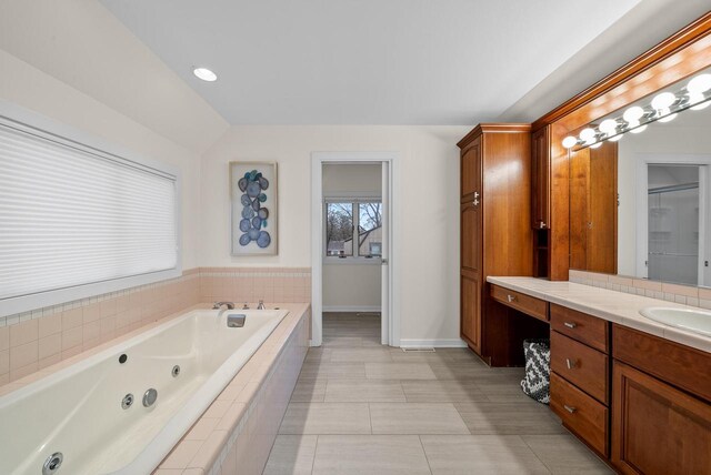 bathroom with a whirlpool tub, tile patterned floors, vanity, and baseboards