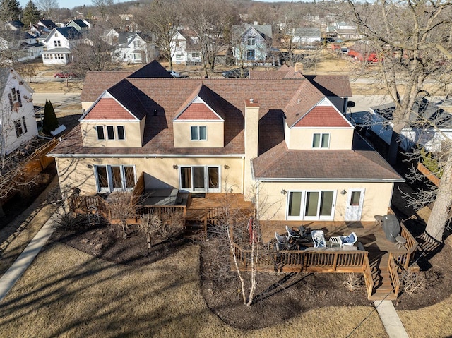 back of house with a residential view, a chimney, outdoor dining space, and stucco siding