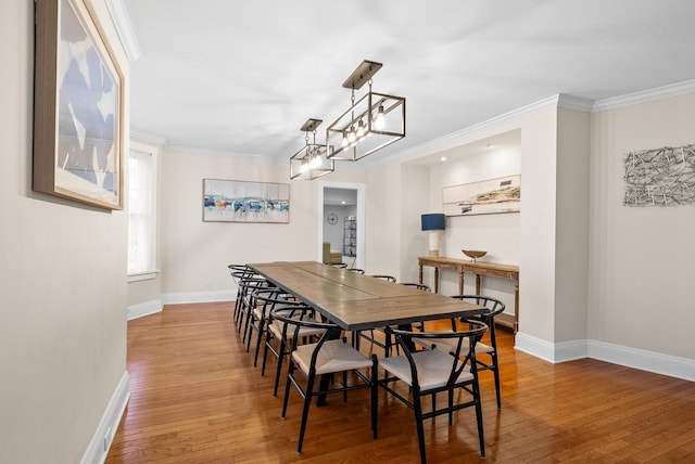 dining space featuring ornamental molding, hardwood / wood-style floors, and baseboards