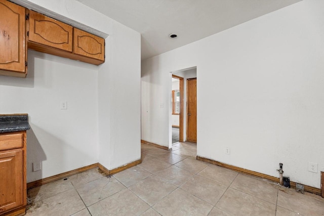 interior space featuring light tile patterned floors and baseboards