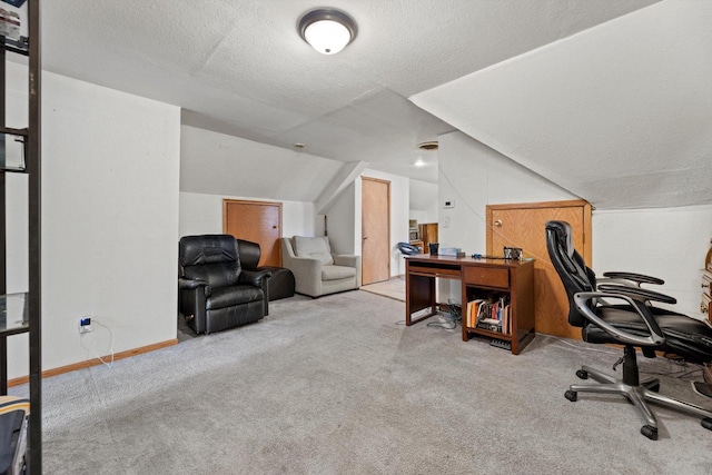 carpeted office featuring baseboards, vaulted ceiling, and a textured ceiling