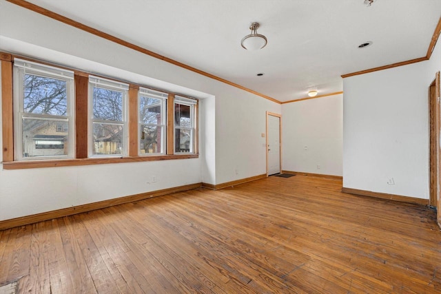 unfurnished room featuring crown molding, baseboards, and hardwood / wood-style floors