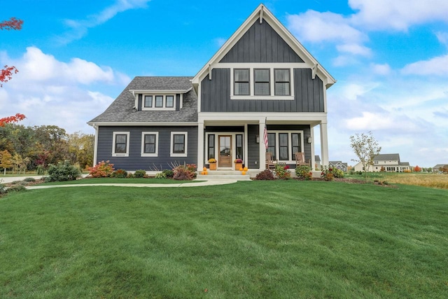 view of front of property with a front lawn, a porch, board and batten siding, and roof with shingles