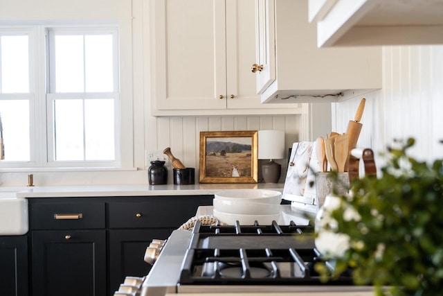 kitchen with dark cabinetry, light countertops, and white cabinetry