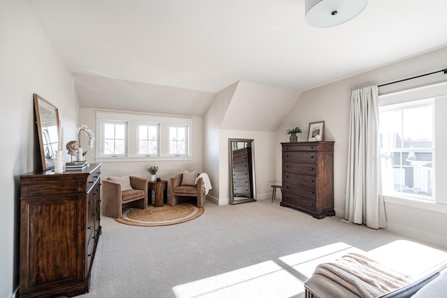 sitting room featuring lofted ceiling, baseboards, and light carpet