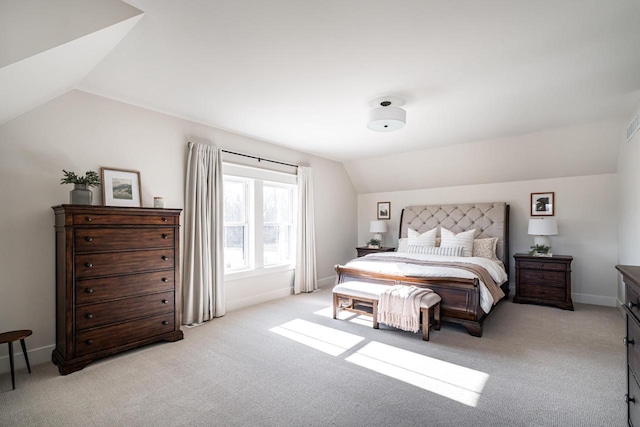 bedroom featuring light colored carpet, baseboards, and vaulted ceiling