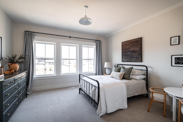 bedroom with carpet flooring, visible vents, baseboards, and ornamental molding