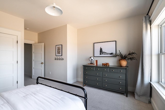 bedroom featuring light colored carpet and baseboards