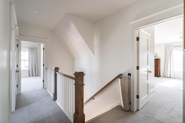 hall featuring an upstairs landing and carpet floors