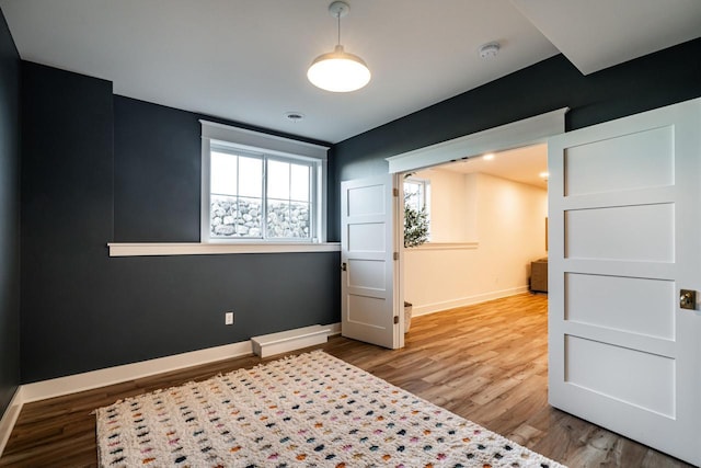 bedroom featuring wood finished floors and baseboards