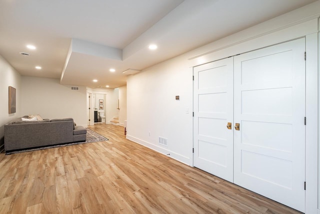 living room featuring stairway, visible vents, baseboards, light wood-style flooring, and recessed lighting