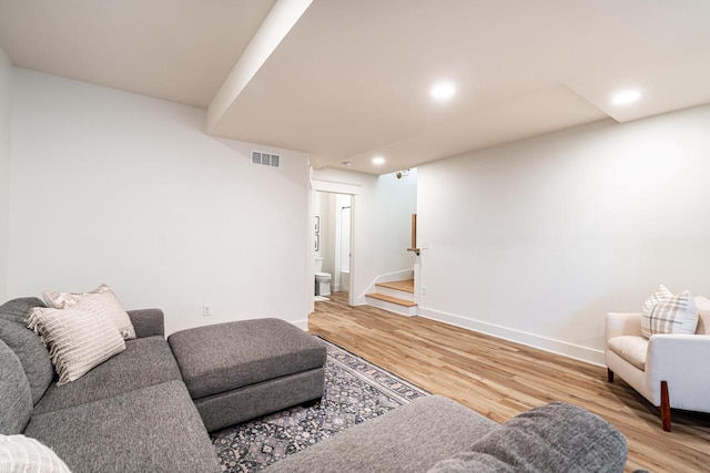 living room featuring light wood finished floors, visible vents, baseboards, stairway, and recessed lighting